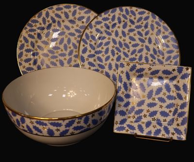 a blue and white bowl and plate set on a black background
