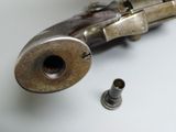 a gun that is laying on a table next to a screw