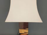 une lampe en bois surmontée d'un abat-jour blanc