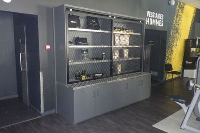 une photo d'une salle de sport avec des appareils fixés au mur