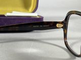 a pair of glasses sitting on a purple case