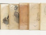 plusieurs vieux livres sont alignés sur une surface blanche