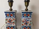 pair of blue and white vases with flowers on them on a table