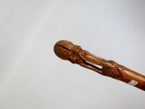 un bâton en bois surmonté d'une tête sculptée