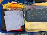 un panier bleu rempli de nombreux vêtements de toutes sortes