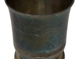 a metal cup that is sitting on top of a table