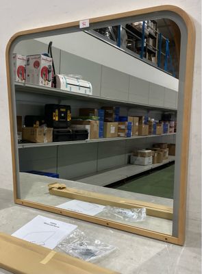 un miroir posé sur un comptoir devant une étagère