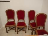 four red chairs are lined up against a white wall in a room