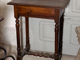a small table with a wooden top in front of a door