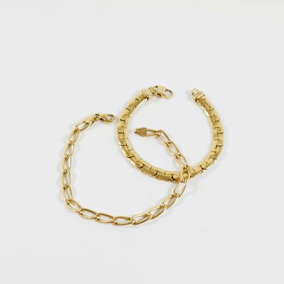 deux bracelets en or posés sur une surface blanche, sur fond blanc