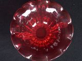 a red glass bowl on a black surface