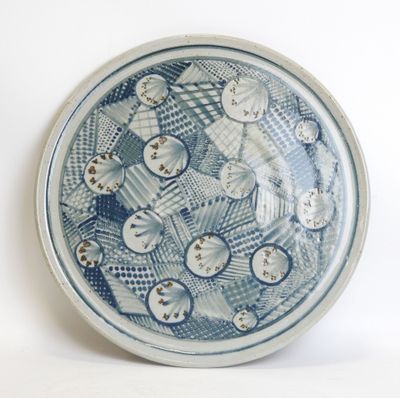 a blue and white plate on a white surface