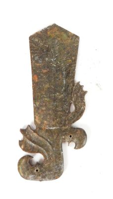 un petit objet en métal sur lequel est représenté un dragon