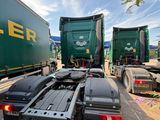 two semi trucks parked next to each other on the road