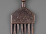 a wooden comb with a monkey head on it