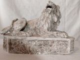 une statue représentant un lion assis sur une table