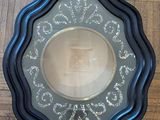 a picture of a black and gold plate on a wooden floor
