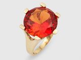a gold ring with a large red stone in the center