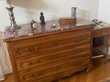 a dresser with a marble top and a lamp on it