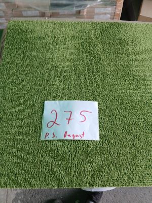 un tapis vert sur lequel est accrochée une étiquette de prix