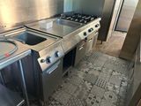 une cuisine équipée d'une cuisinière, d'un évier et d'un réfrigérateur