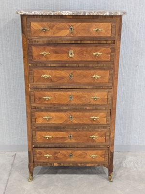a wooden chest of drawers with marble top and brass handles