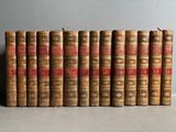 several old books lined up in a row on a table
