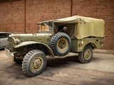 an old military truck parked in front of a brick wall