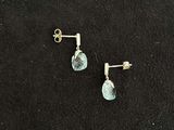 pair of earrings with blue topaz stone on black background