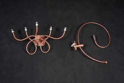 PESCATORE. Suite de deux applique à volutes en métal patiné …