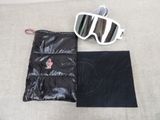 une paire de lunettes de soleil et une pochette posées sur un lit