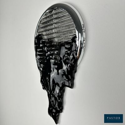 photographie en noir et blanc d'une sculpture représentant une tête d'homme sur un mur