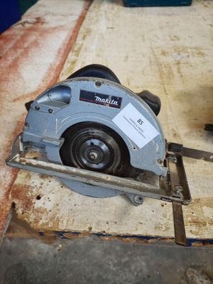someone is using a circular saw to cut a piece of wood