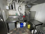 une cuisine équipée d'un évier, d'une cuisinière et d'autres éléments