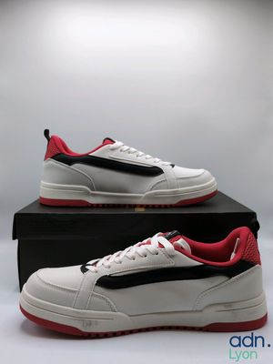 a pair of white and red sneakers on a black box