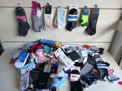 de nombreuses paires de chaussettes suspendues les unes à côté des autres sur le mur