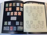 an open book with stamps on it on a table