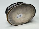 a silver vase with a label on it on a white surface