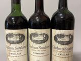 three bottles of red wine are lined up on a table