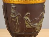 a vase with a painting on it sitting on a table