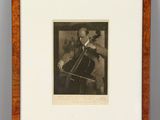 a black and white photo of a man playing a cello