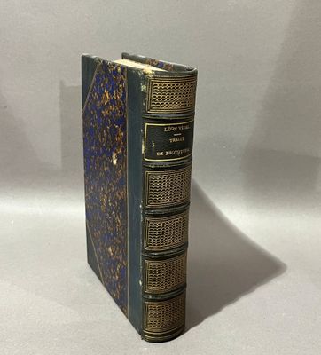 un vieux livre posé sur une table blanche à côté d'un mur blanc