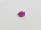 a pink plastic button sitting on top of a white surface