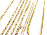 a close up of a bunch of gold chains on a white surface