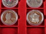 four silver coins in a red case on a red surface