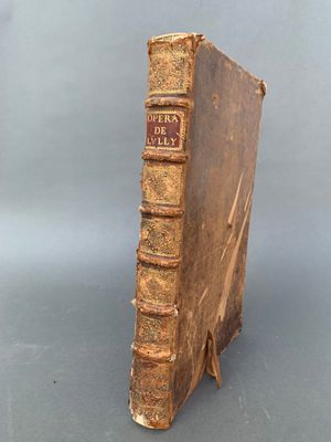 un vieux livre posé sur un support en bois, sur une table