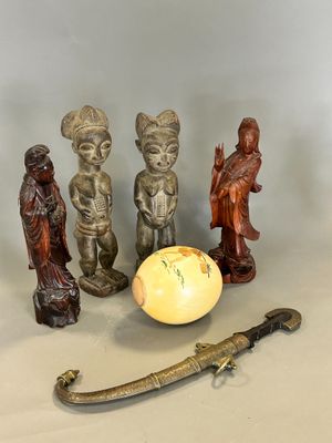 three figurines that are sitting next to a yellow egg