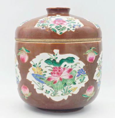 un vase marron orné de fleurs sur un fond blanc