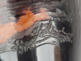 a close up of a vase with a bird on it