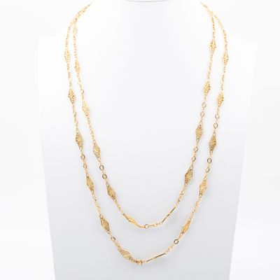 a gold necklace with three layers of chain and a gold disc